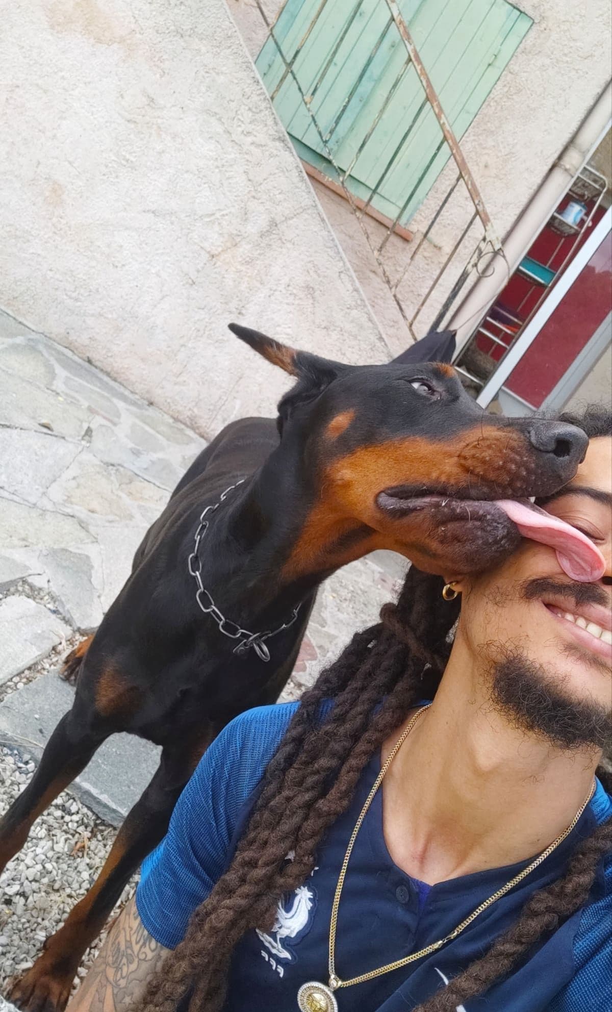 Arnaud avec un Doberman complice dans son jardin de Nice